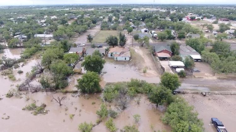 A drone image shows flooded homes after torrential rains caused flooding along the Concho River in San Angelo, Texas.