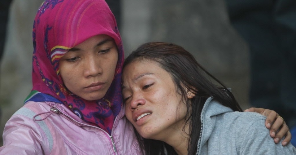 30.jun.2015 - Parentes de vítimas do acidente com o avião de transporte militar indonésio C-130 Hercules lamentam em hospital da cidade de Medan, na ilha de Sumatra, Indonésia. O acidente incendiou casas e veículos e matou mais de cem pessoas