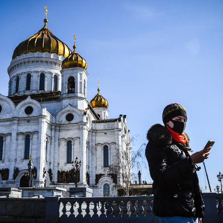 26.mar.2020 - Mulher usando máscara na Catedral de Cristo Salvador no centro de Moscou - ALEXANDER NEMENOV/AFP