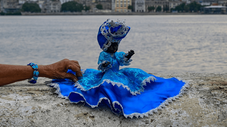 07.set.26 - Mulher ajeita imagem da Virgem de Regla (Yemanjá, na religião iorubá) durante o dia de sua festa em Havana - undefined