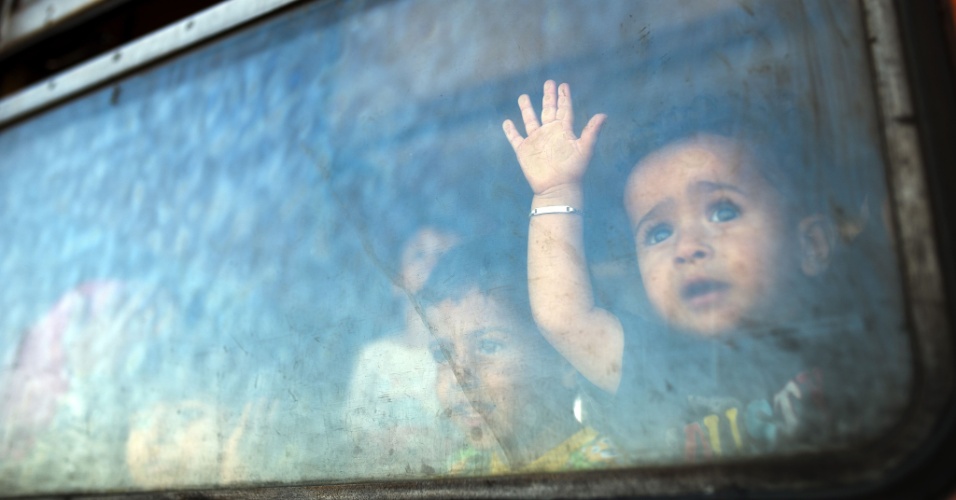 28.ago.2015 - Menino refugiado obersva através da janela de um trem, que tem a Sérvia como destino, o novo centro de trânsito para os imigrantes, na fronteira da Grécia com a Macedônia