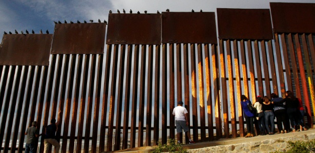 Em Tijuana (México), pessoas falam com parentes que estão do outro lado da cerca que separa o México dos Estados Unidos - Jorge Duenes/Reuters