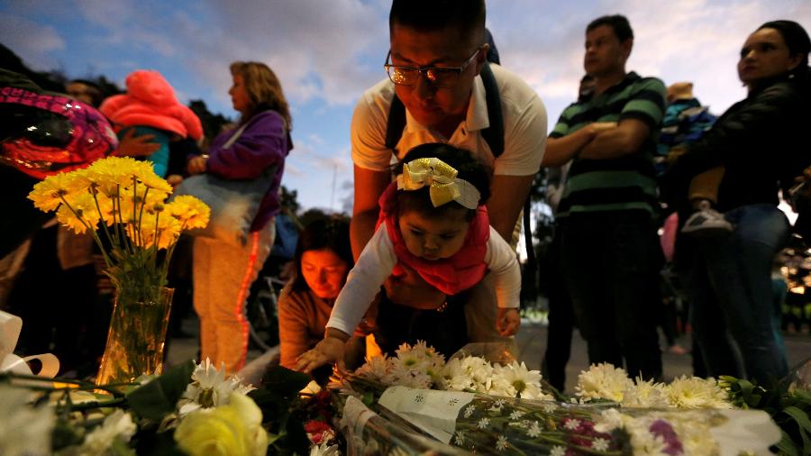 Em homenagem às vítimas, velas e flores são colocadas no local onde um carro explodiu em Bogotá  - Luisa Gonzalez/Reuters
