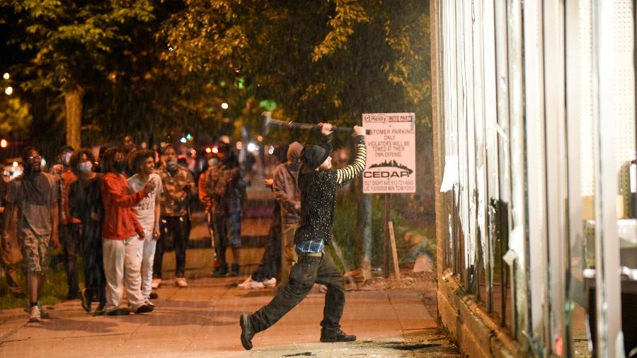 27.mai.2020 - Manifestante quebra vidro de estabelecimento em Minneapolis, nos EUA; protestos ocorrem após morte de homem negro em ação da polícia - Nicholas Pfosi/Reuters