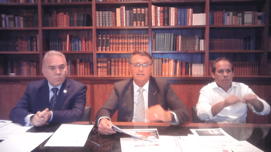 O presidente Jair Bolsonaro, o ministro Marcelo Queiroga e o intérprete de libras Fabiano Guimarães durante transmissão ao vivo - Reprodução
