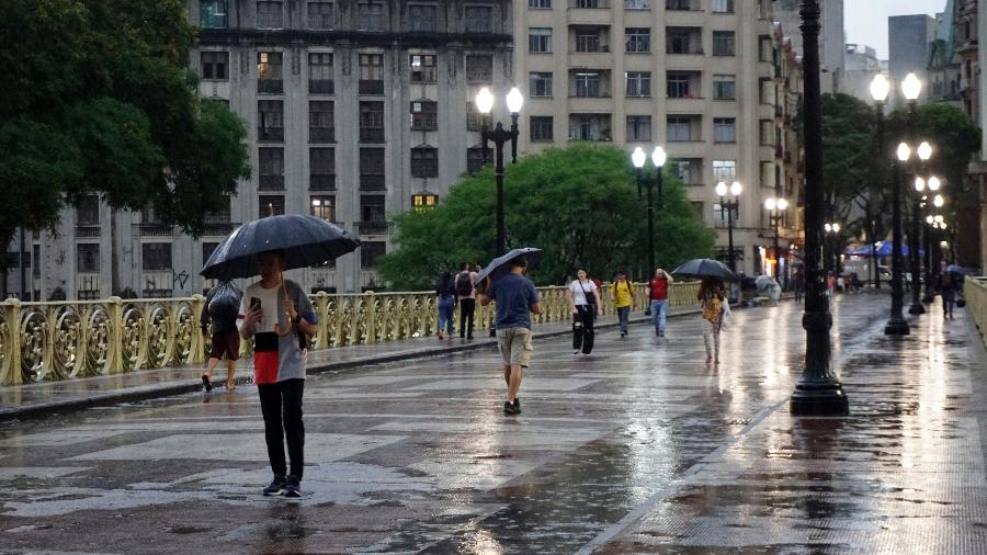 7.out.2023 - Pedestres passam pelo Viaduto Santa Ifigênia, no centro de São Paulo, em meio à chuva que atinge a cidade.
