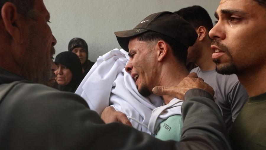 23.abr.2025 - Homem chora enquanto carrega o corpo de uma criança, que morreu em um ataque israelense ontem 23.abr.2025 - Homem chora enquanto carrega o corpo de uma criança, que morreu em um ataque israelense ontem