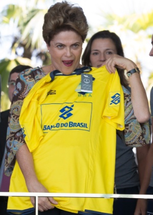 A presidente Dilma Rousseff prova a camisa do Brasil com seu nome durante almoço com atletas das equipes feminina e masculina da Seleção Brasileira de Vôlei de Praia - Ed Ferreira/ Brazil PhotoPress/ Estadão Conteúdo