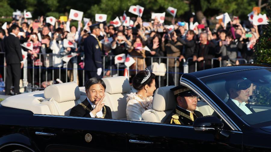 10.nov.2019 - Imperador Naruhito, do Japão, e imperatriz Masako desfilam em Tóquio, em carro aberto, pela primeira vez desde seu casamento, em 1993. Milhares de japoneses foram às ruas da cidade para acompanhar o desfile - Farzaneh Khademian/AFP