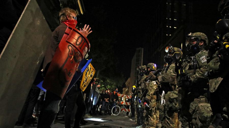 Policiais federais enfrentam manifestantes durante um protesto contra a desigualdade racial e a violência policial em Portland, Oregon, EUA - CAITLIN OCHS/REUTERS