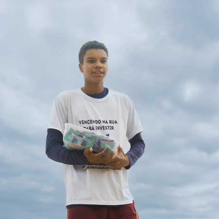 Gabriel Souza vendia doce na praia, usando uma camiseta com a frase “Vencendo na rua para investir”