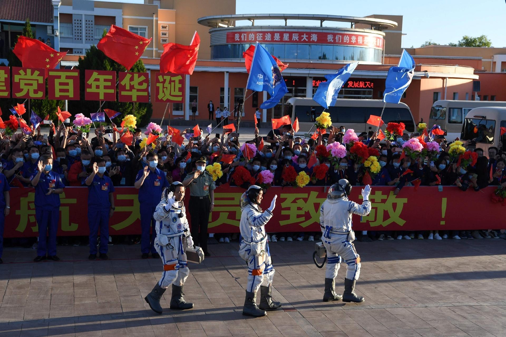 Os taikonautas chineses são saudados pelo público antes do lançamento - Greg Baker / AFP