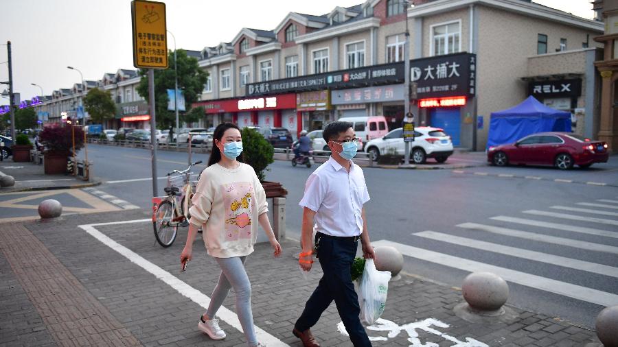 Moradores caminham por rua de Xangai, na China, após alívio em quarentena por surto de covid-19 - cnsphoto via Reuters