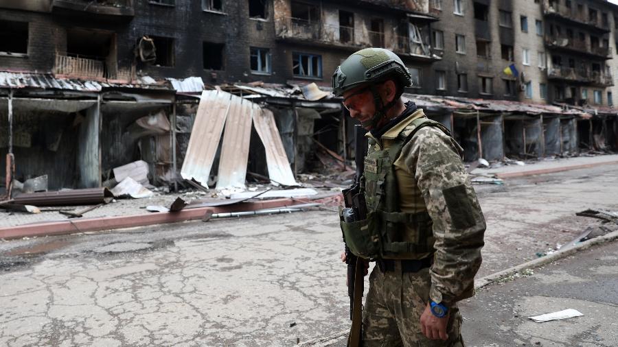 Militar ucraniano caminha em área com prédios destruídos na cidade de Siversk, na região de Donetsk, no leste do país - 22.jul.2022 - Anatolii Stepanov/AFP