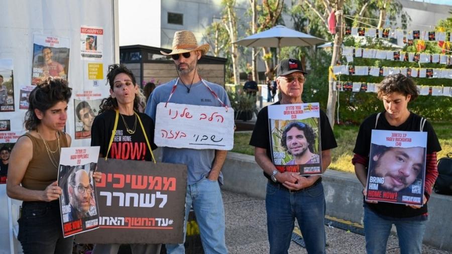16.dez.2023 - Parentes e apoiadores de reféns israelenses, detidos em Gaza desde o ataque de 7 de outubro, seguram seus retratos durante uma manifestação pedindo sua libertação, em frente ao Museu de Arte de Tel Aviv