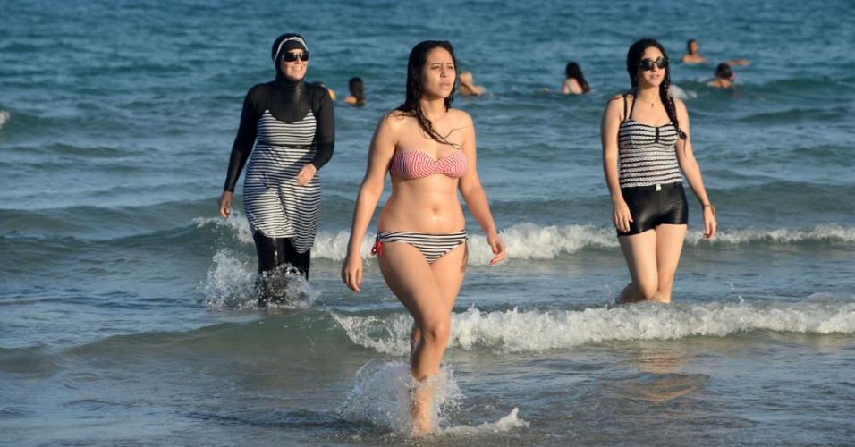 AGOSTO: A POLÊMICA DO BURQUÍNI - Várias mulheres, incluindo uma de burquíni, a roupa de banho de corpo inteiro, mergulham no mar de Ghar al Milh, na Tunísia. Usado por algumas muçulmanas, a peça se tornou centro de uma polêmica após o ataque terrorista ocorrido em Nice, em julho, quando um homem dirigindo um caminhão atropelou e matou 86 pessoas. Durante os meses de verão, os prefeitos de dezenas de cidadezinhas litorâneas proibiram a vestimenta nas praias locais, alegando razões como ameaça à manutenção da ordem pública e a aplicação do princípio nacional do secularismo. Posteriormente, o Conselho de Estado reverteu a proibição, considerando-a uma infração das liberdades individuais básicas, embora muitos municípios a tenham desafiado