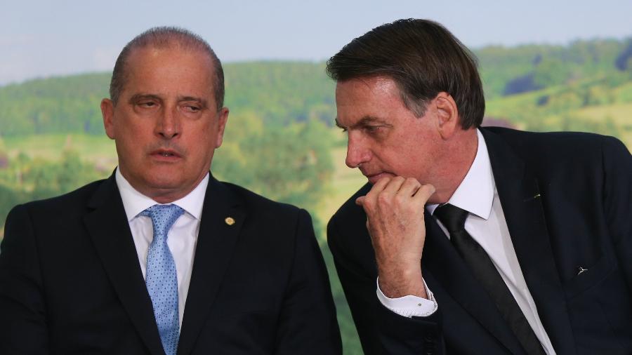 18.jun.2019 - O ministro da Casa Civil Onyx Lorenzoni conversa com o presidente Jair Bolsonaro durante cerimônia no Palácio do Planalto - Andre Coelho/Folhapress