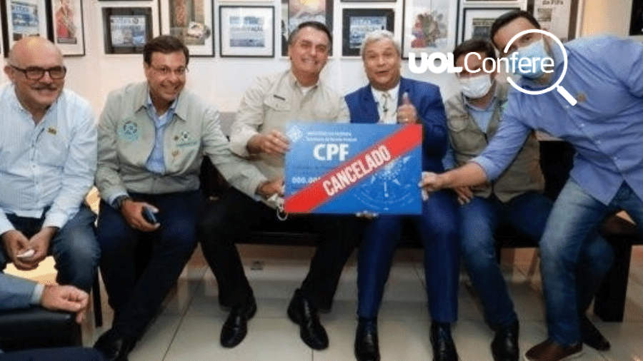 O presidente Jair Bolsonaro segura cartaz "CPF cancelado" durante visita a Manaus - Reprodução