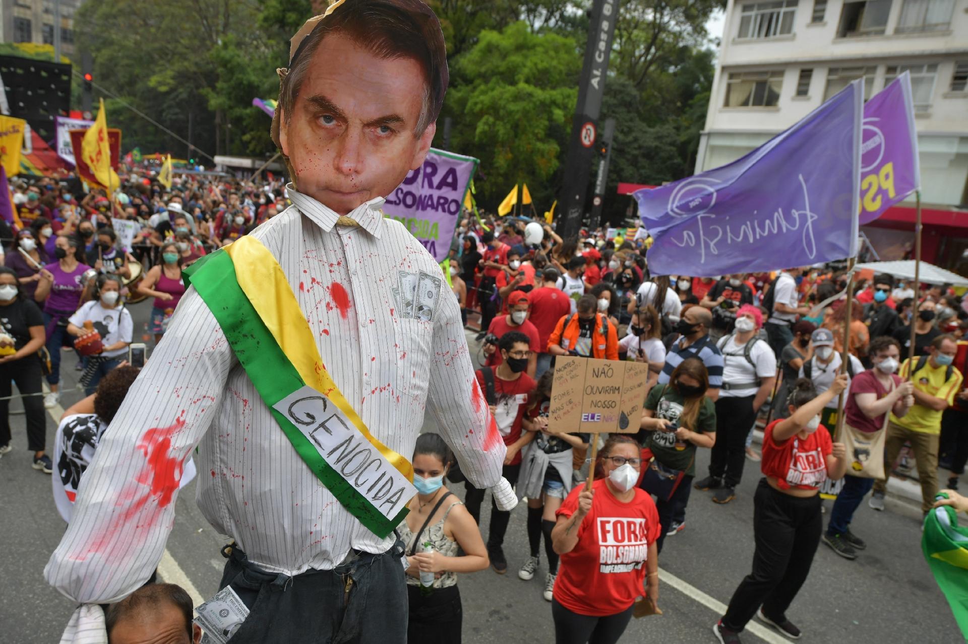Manifestantes carregam boneco com a imagem do presidente Jair Bolsonaro e uma faixa escrita "genocida" em ato realizado na avenida Paulista, em São Paulo - NELSON ALMEIDA / AFP