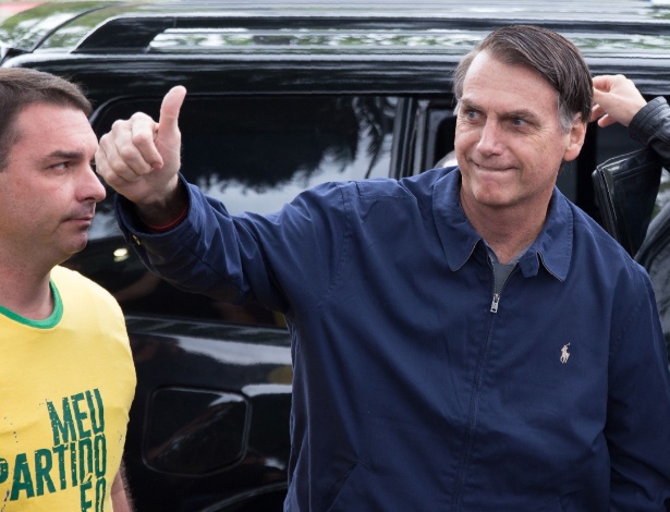 7.out.2018 - Flavio e Jair Bolsonaro na chegada para votar no primeiro turno, no Rio - Fernando Souza/AFP