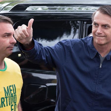 7.out.2018 - Flavio e Jair Bolsonaro durante votação  no Rio - Fernando Souza/AFP