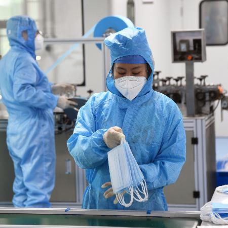 11/03/2020 - Funcionária analisa máscaras de proteção ao coronavírus em Pequim - Xinhua/Ren Chao
