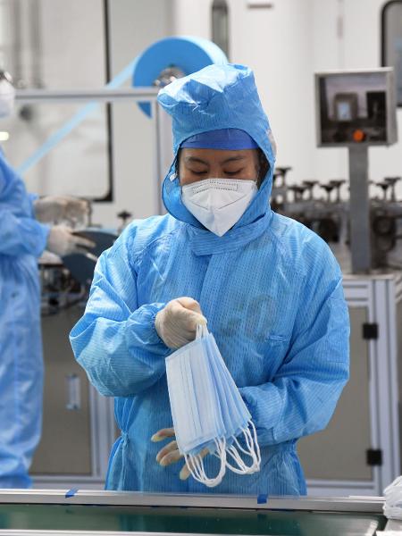 Funcionária analisa máscaras de proteção ao coronavírus em Beijing na China  - Xinhua/Ren Chao