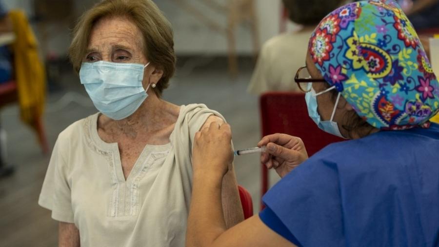 10.fev.2021 - Idosa recebe dose de vacina contra a covid-19 em Santiago, no Chile - Martin Bernetti/AFP