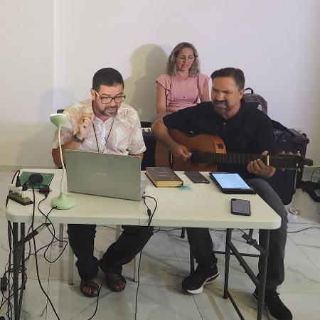 Pastor e membros cantam durante culto online