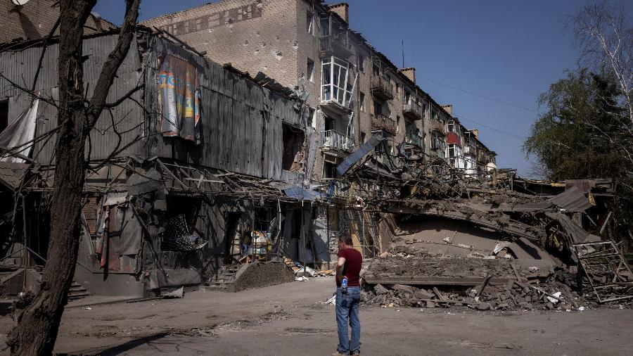 Um homem observa os danos causados pelo bombardeio em Kostiantynivka, em meio ao ataque da Rússia à Ucrânia