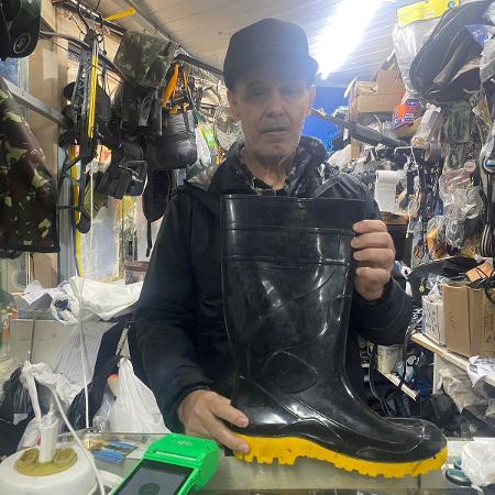 O comerciante Luiz Carlos dos Santos só tem vendido botas de borracha e lanternas no centro histórico de Porto Alegre