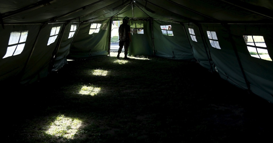 2.set.2015 - Um soldado do exército suíço caminha em uma tenda fora de um campo de refugiados em Lyss
