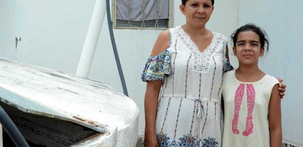 Teodora Maria Dantas, 39, e a filha, Keyla Beatriz, 12, acumulam água em cisterna com abertura em Palmeira dos Índios (AL) - Beto Macário/UOL