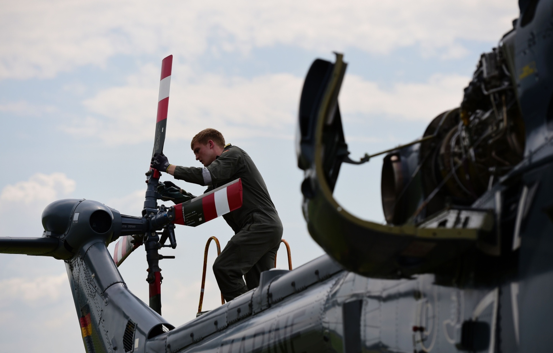 30.mai.2016 - Soldado das forças armadas da Alemanha inspeciona o motor de um helicóptero para o International Aerospace Exhibition (ILA), no aeroporto de Schoenefeld, próximo a Berlim, na Alemanha - Tobias Schwarz/AFP Photo