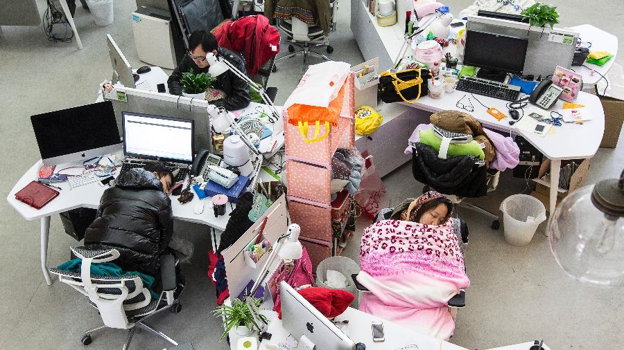 Funcionários tiram sonecas durante a hora do almoço na empresa Tencent em Guangzhou, China. - Qilai Shen/The New York Times