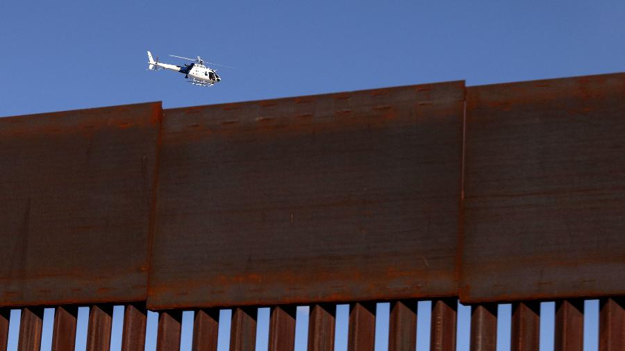 31.jan.2020 - Foto de arquivo mostra helicóptero da Patrulha da Fronteira dos EUA sobrevoando a área de Anapra, em Sunland Park, Novo México e a cerca da fronteira em Ciudad Juarez, no México - Herika Martinez/AFP