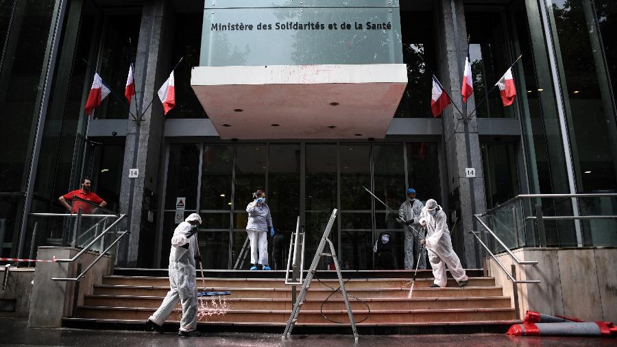 20.jun.2020 - Funcionários limpam fachada do ministério da Saúde da França que foi coberto de tinta vermelha por manifestantes - Anne-Christine Poujoulat/AFP