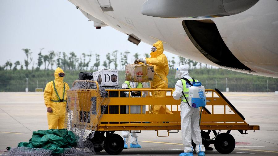Wuhan volta a receber voo internacional; funcionários usam roupas de proteção - Reuters