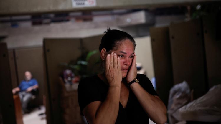 Mulher chora após deixar casa em Eldorado do Sul
