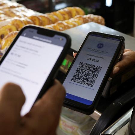 Cliente usa celular para pagar via Pix em loja no Rio de Janeiro