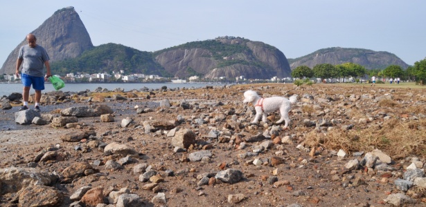 Homem caminha e observa cenário de destruição provocado pela força do mar na praia do Flamengo, na zona sul carioca - Alessandro Buzas/Estadão Conteúdo