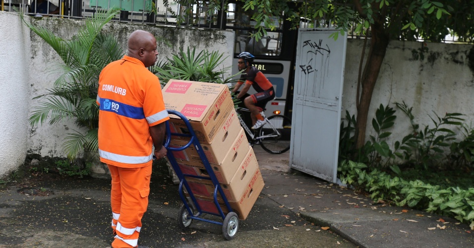 Funcionário de limpeza transporta caixas contendo urnas eletrônicas no Rio de Janeiro