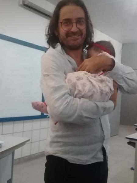 Professor Joserrí de Oliveira Lucena segura a bebê Alice durante uma aula de história em Natal - Arquivo pessoal
