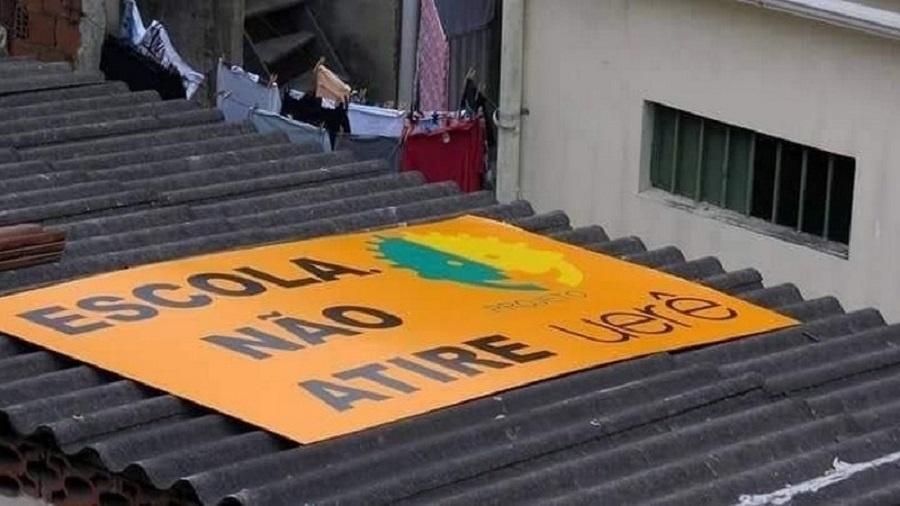 Projeto social no Complexo da Maré utilizou placa em teto de escola para protestar contra sobrevoos de helicópteros - Reprodução/Twitter/@renatasouzario