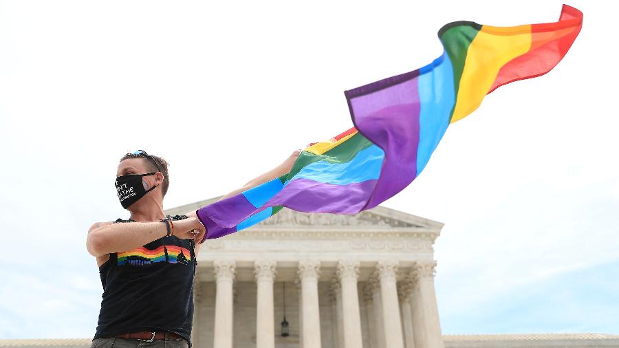 Homem com bandeira do orgulho gay em frente ao prédio da Suprema Corte dos EUA - TOM BRENNER