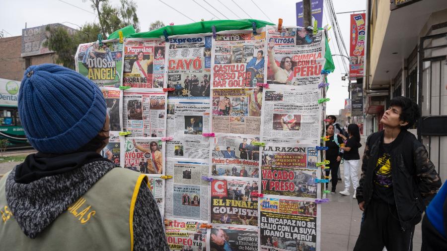 8.dez.2022 - Pessoas leem capas de jornais em Lima, um dia após o presidente do Peru, Pedro Castillo, ser destituído - Cris Bouroncle/AFP