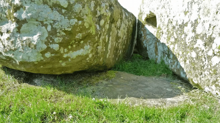 A Pedra do Altar, plana e parcialmente enterrada de Stonehenge, vista aqui sob duas pedras de sarsen