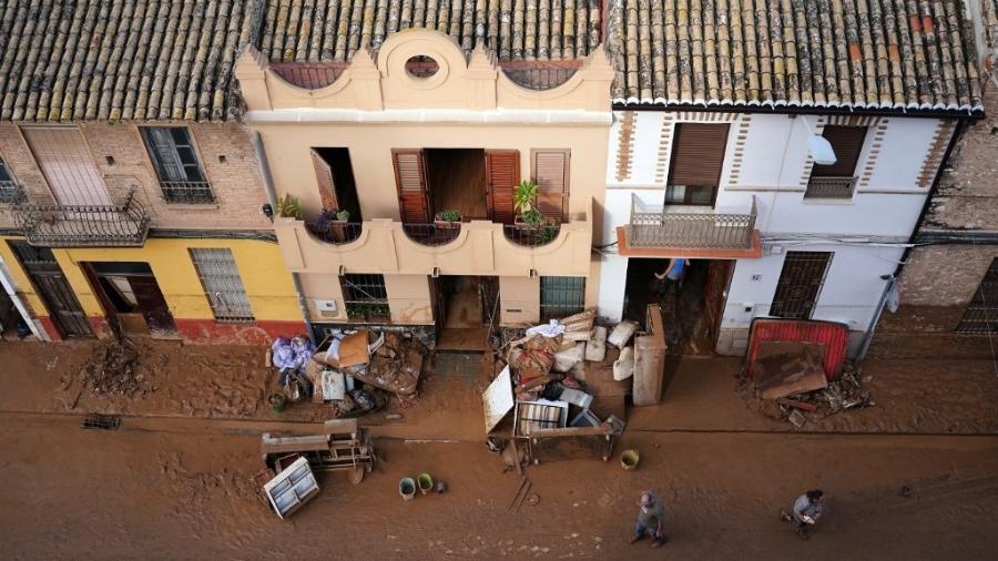 31.out.2024 - Entulhos se acumulam em uma rua coberta de lama em La Torre, Valência, na Espanha