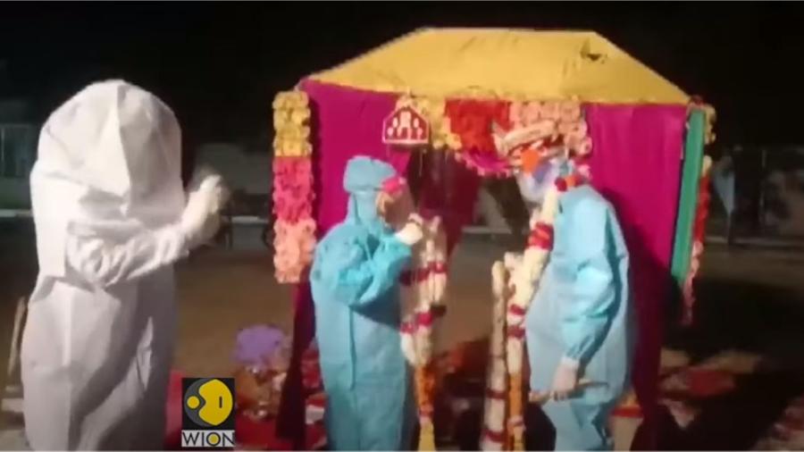 Casal se casa em Baran, no estado indiano de Rajasthan, vestindo roupas de proteção contra a covid-19 - Reprodução/WION/Youtube