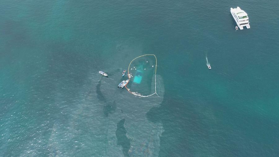 Foto aérea mostra uma vista aérea de guardas colocando material absorvente onde um barco afundou em 23 de abril de 2022 perto de Puerto Ayora, nas Ilhas Galápagos - AFP PHOTO / PARQUE NACIONAL GALAPAGOS